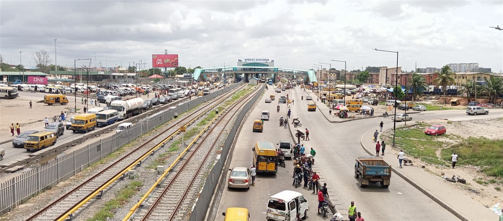 Mile 2 station and the expressway, busy with buses and traders
